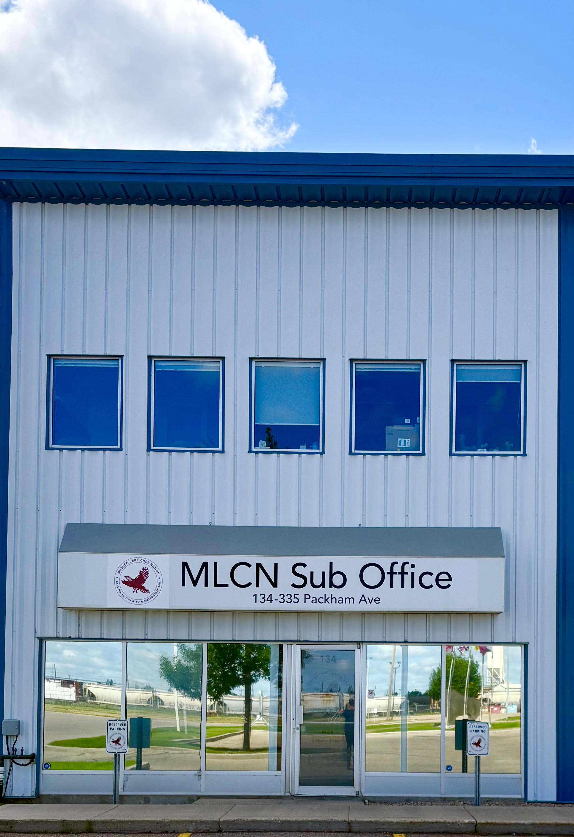 The MLCN Sub-Office storefront at 134-335 Packham Avenue: a white building with the crest on the sign over the door